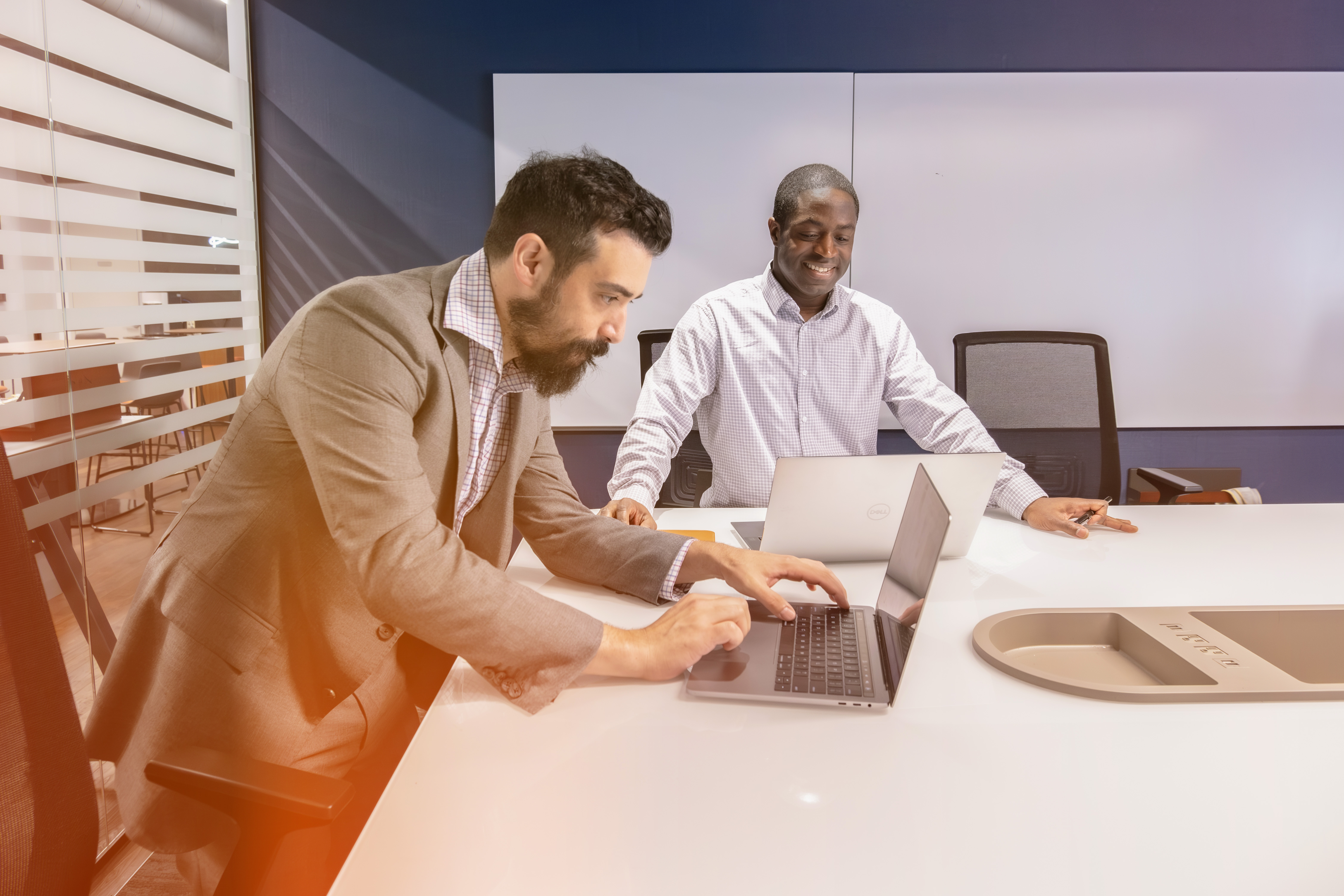 Two employees collaborating on a laptop