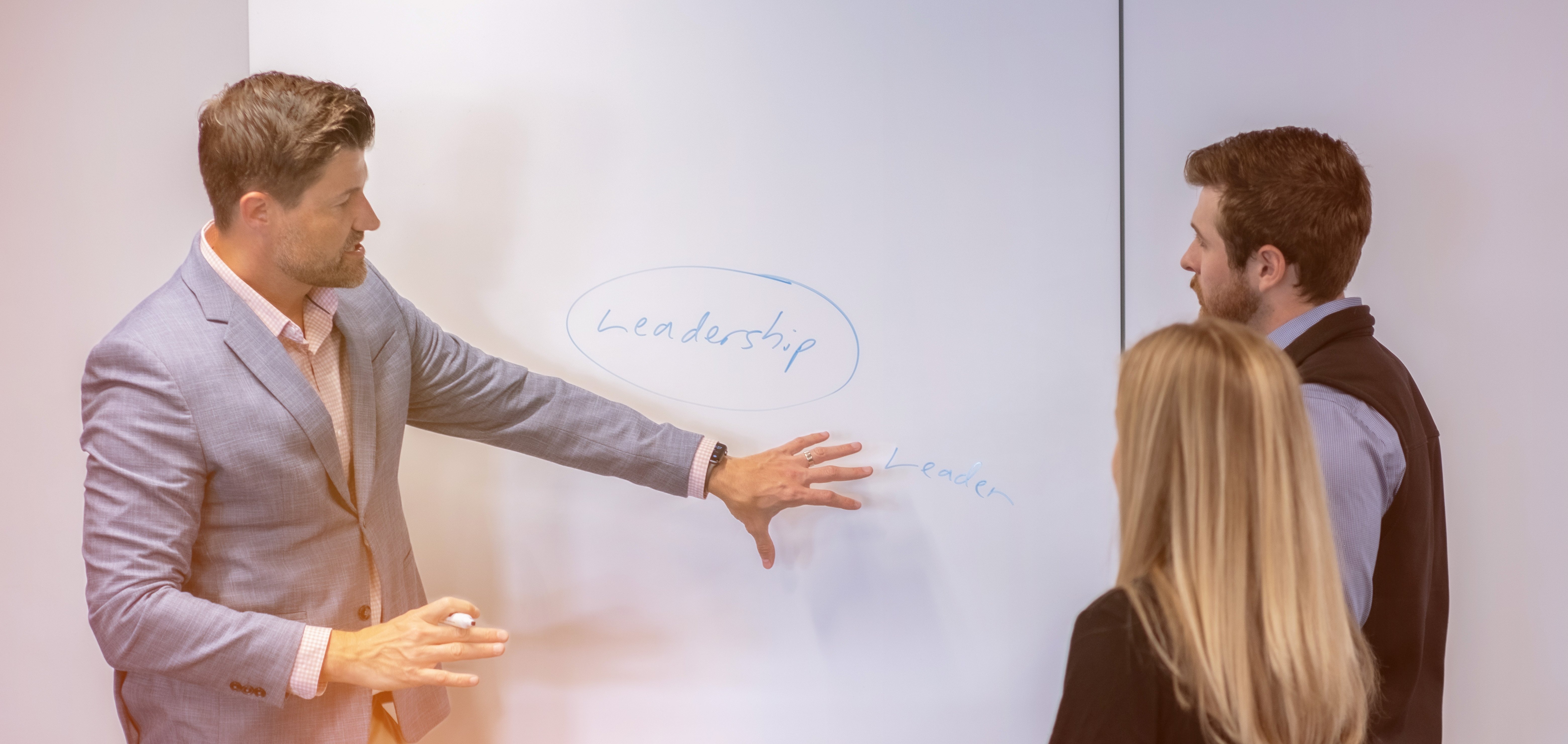 Group of Employees Gathered around Whiteboard